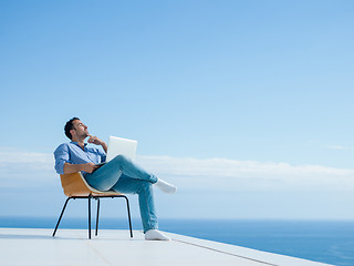 Image showing relaxed young man at home on balcony