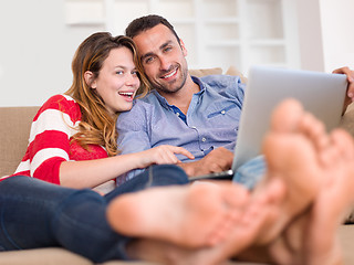 Image showing relaxed young couple working on laptop computer at home