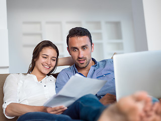 Image showing relaxed young couple working on laptop computer at home