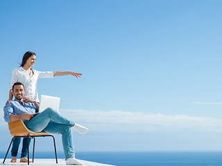 Image showing relaxed young couple working on laptop computer at home