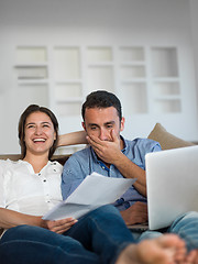 Image showing relaxed young couple working on laptop computer at home