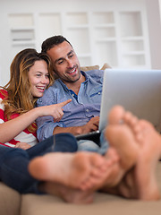 Image showing relaxed young couple working on laptop computer at home