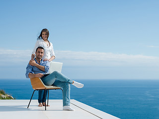 Image showing relaxed young couple working on laptop computer at home