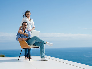 Image showing relaxed young couple working on laptop computer at home