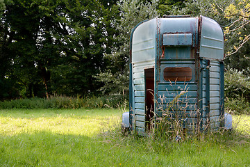 Image showing Weathered horsebox standing in a meadow 