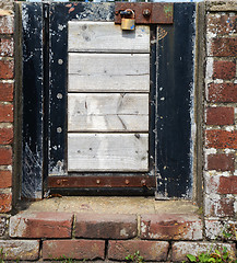 Image showing Small locked gate in a brick wall