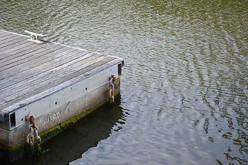 Image showing Weathered wooden jetty in calm water