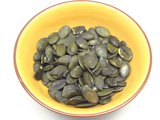 Image showing Pumpkin seeds in bowl of ceramic on white background