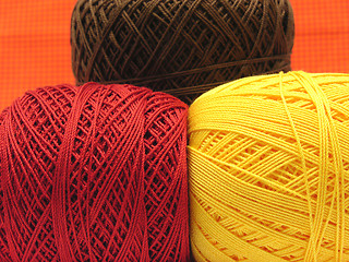 Image showing Three  balls of wool  in yellow, brown and red