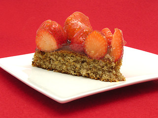 Image showing One slice of strawberry cake on white plate on red background