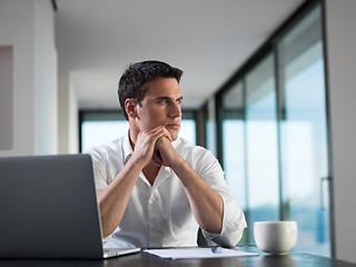 Image showing business man working on laptop computer at home