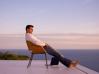 Image showing relaxed young man at home on balcony