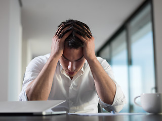 Image showing frustrated young business man working on laptop computer at home