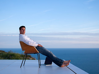 Image showing relaxed young man at home on balcony