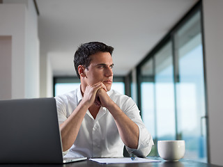 Image showing business man working on laptop computer at home