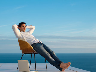 Image showing relaxed young man at home on balcony