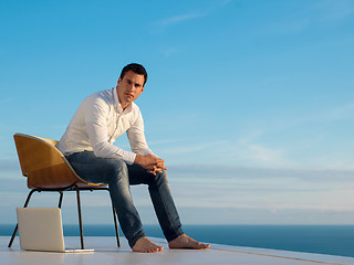 Image showing relaxed young man at home on balcony