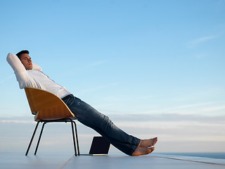 Image showing relaxed young man at home on balcony