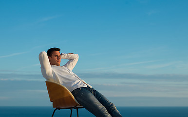 Image showing relaxed young man at home on balcony