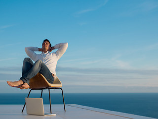 Image showing relaxed young man at home on balcony