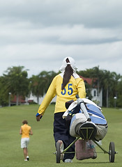 Image showing Golf caddie and player