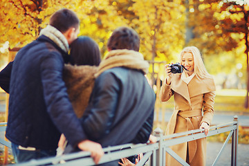 Image showing group of friends with photo camera in autumn park