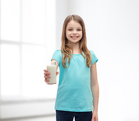 Image showing smiling little girl giving glass of milk