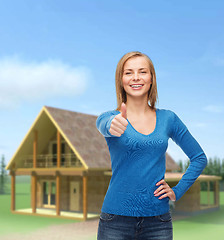 Image showing smiling girl in casual clothes showing thumbs up