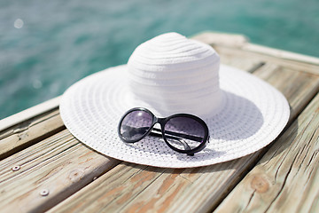 Image showing close up of hat and sunglasses at seaside