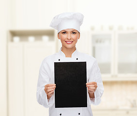 Image showing smiling female chef with black blank paper