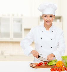 Image showing smiling female chef chopping vegetables