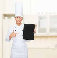 Image showing smiling female chef with black blank paper