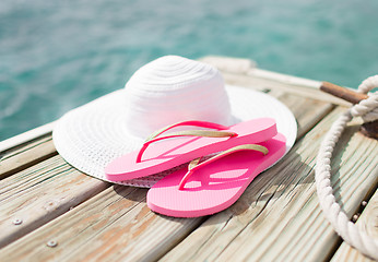 Image showing close up of hat and slippers at seaside