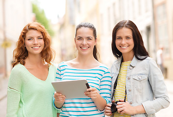 Image showing smiling teenage girls with tablet pc and camera