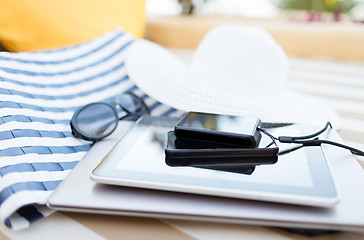 Image showing close up of tablet pc and smartphone on beach