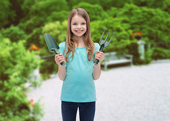 Image showing smiling little girl with rake and scoop