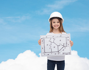 Image showing smiling little girl in helmet showing blueprint