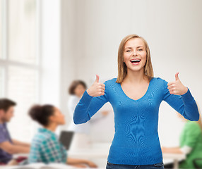 Image showing smiling girl in casual clothes showing thumbs up