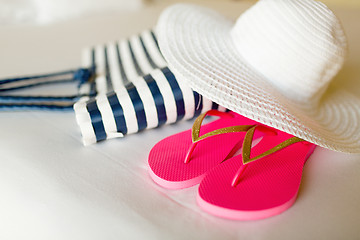 Image showing close-up of beach bag, hat and flip-flops on bed