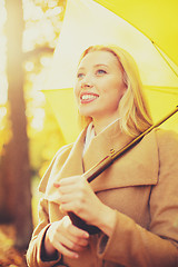 Image showing woman with yellow umbrella in the autumn park