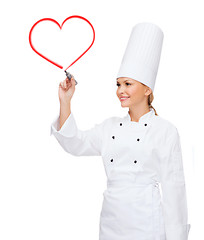 Image showing smiling female chef writing something on air