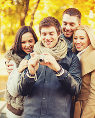 Image showing group of friends with photo camera in autumn park