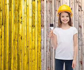 Image showing smiling little girl in helmet with paint roller