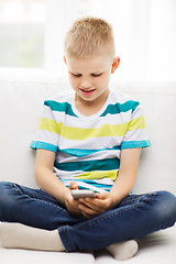 Image showing smiling little boy with smartphone at home