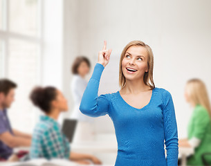 Image showing smiling woman pointing her finger up