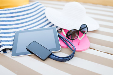 Image showing close up of tablet pc and smartphone on beach