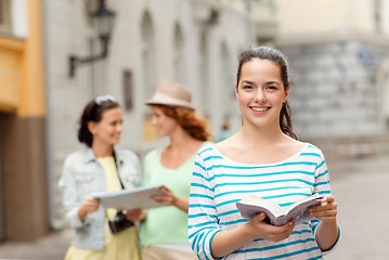 Image showing smiling teenage girls with city guides and camera