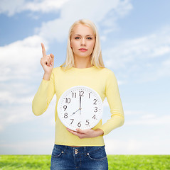 Image showing student with wall clock and finger up