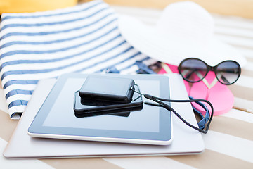 Image showing close up of tablet pc and smartphone on beach