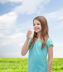 Image showing smiling little girl drinking milk out of glass